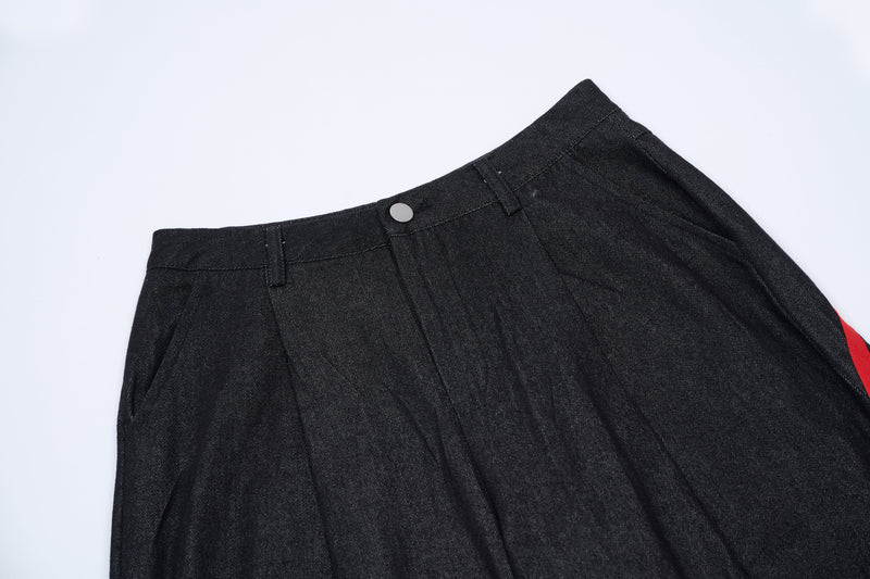 Dark denim pants waistband with button closure and belt loops, close-up