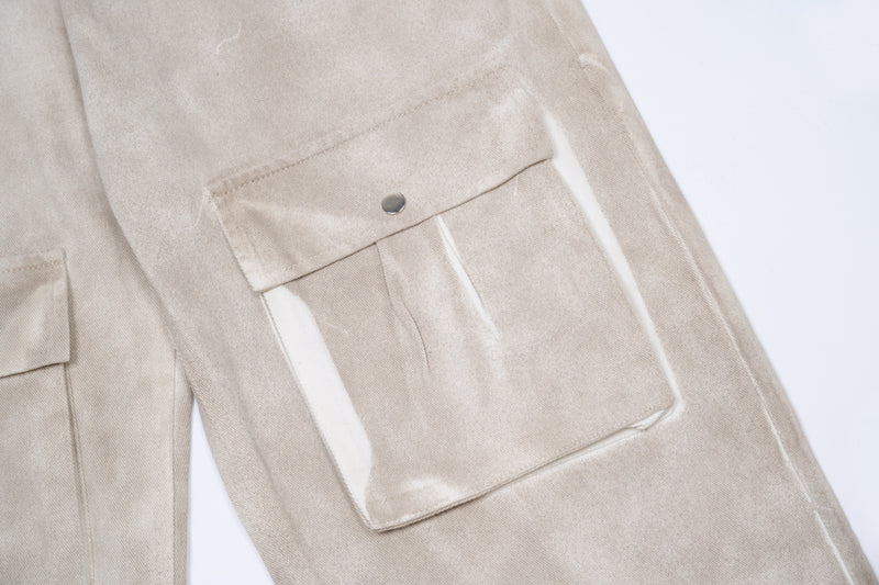 Close-up of side cargo pocket with snap flap on beige pants