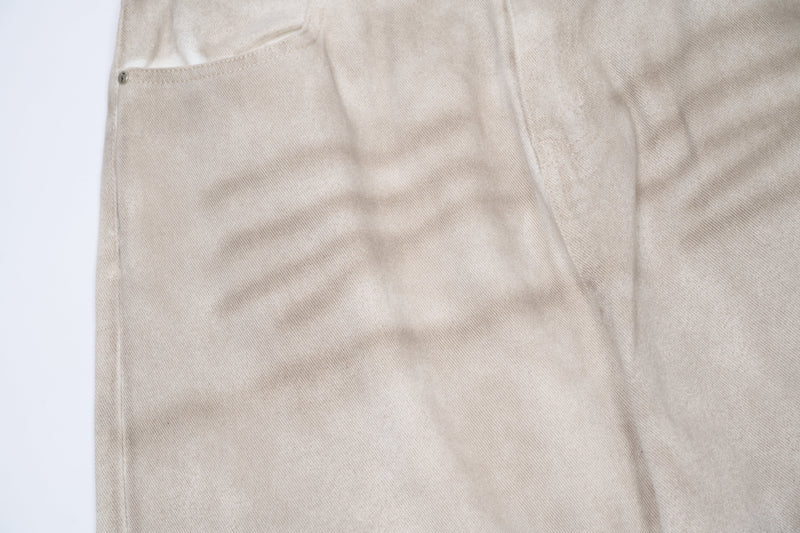 Close-up of beige cotton pants pocket and stitched waist seam