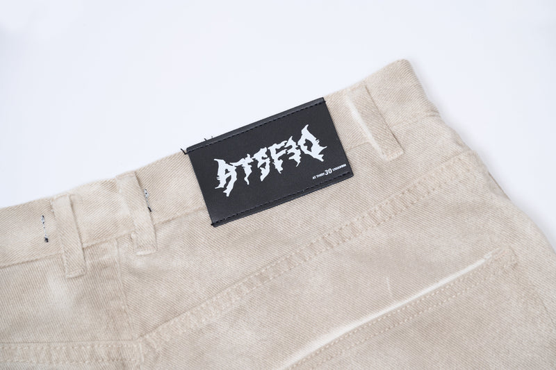 Close-up of black label on beige cotton waistband with topstitching