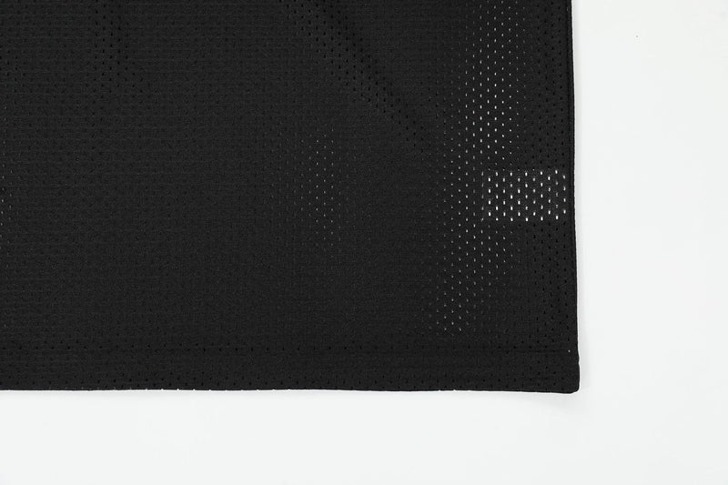Black mesh football tee fabric with perforated leather-look panels and clean hem on white background