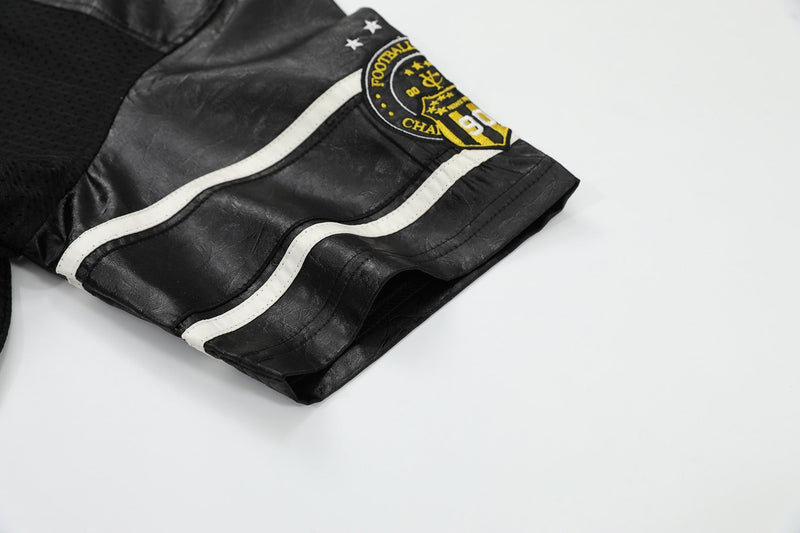 Black streetwear football tee with white curved trim and yellow crest patch on the sleeve, shown folded on a white background