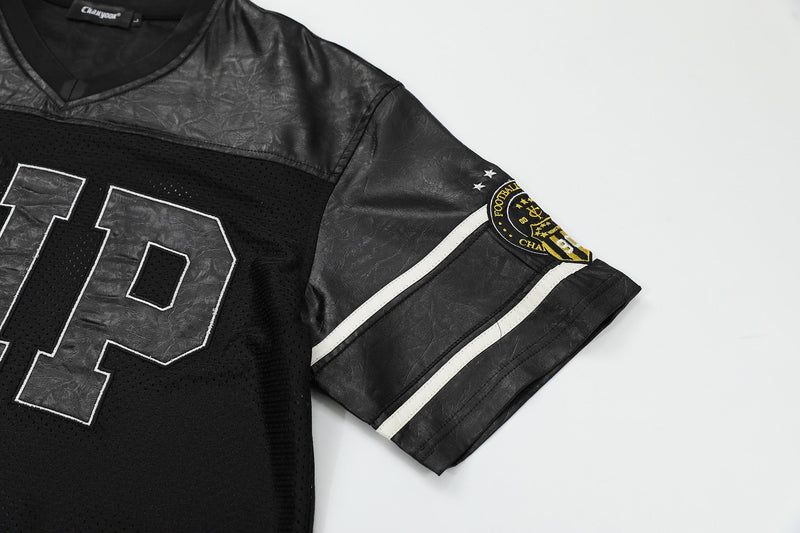 Black mesh football tee with leather-look panels, oversized front number, and striped sleeve patch on a white background