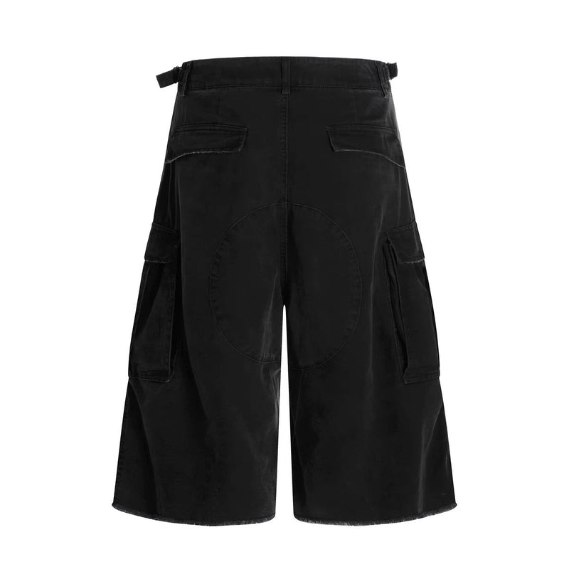 Black cargo shorts back view with flap pockets, wide-leg cut, and layered panel detail at the hem