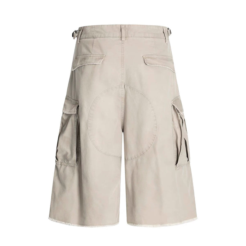 Beige cargo shorts back view with flap pockets, wide-leg cut, and large circular seam detail