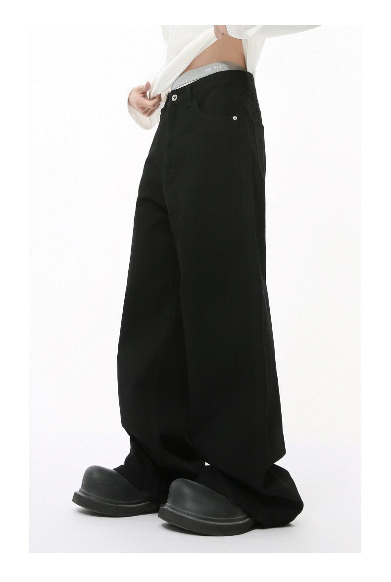 Solid black wide-leg jeans worn by model, side view with waistband visible