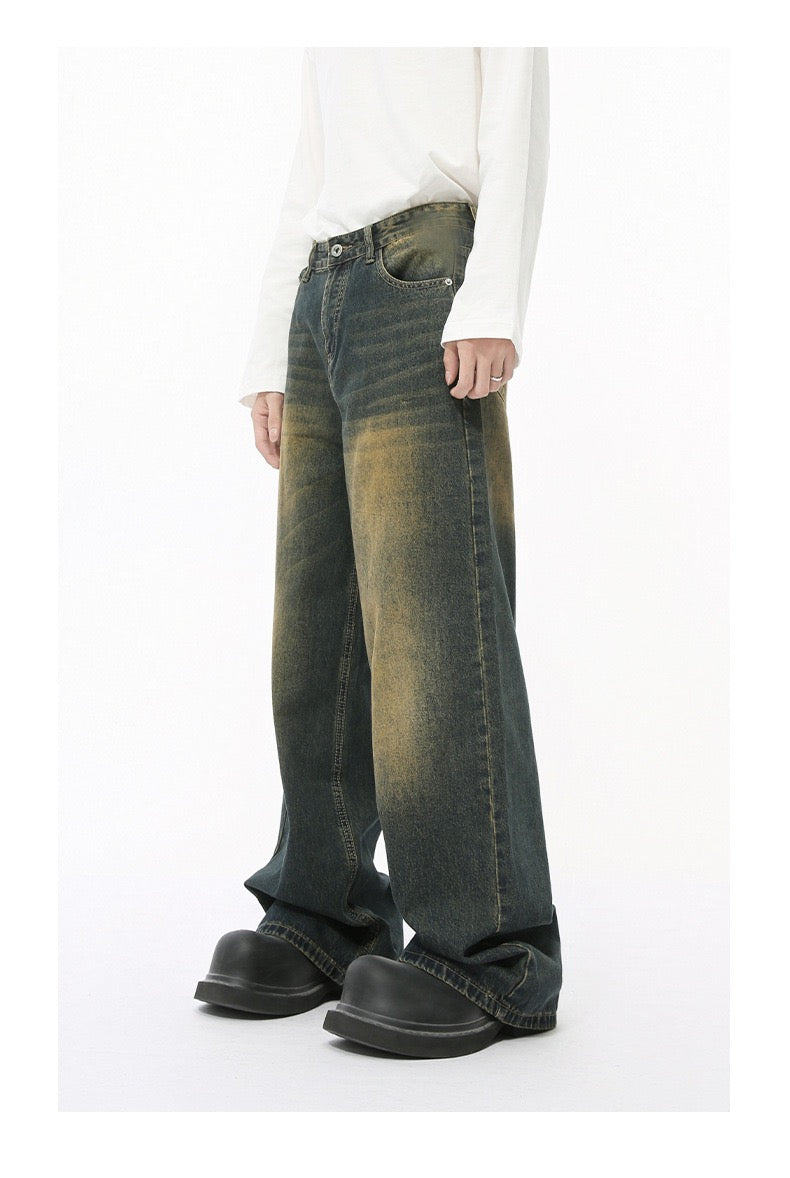 Olive black wide-leg jeans with yellow faded wash worn by model, side view