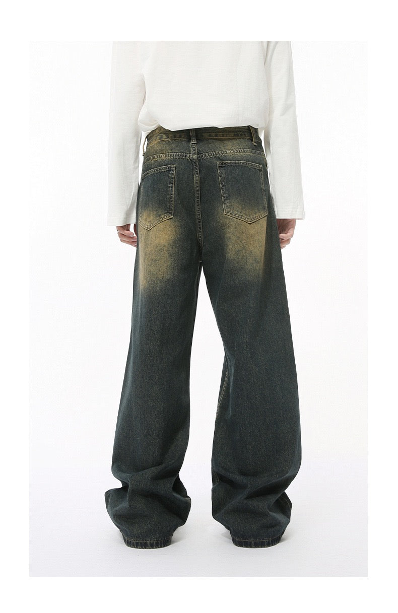 Olive black wide-leg jeans with yellow faded wash worn by model, back view