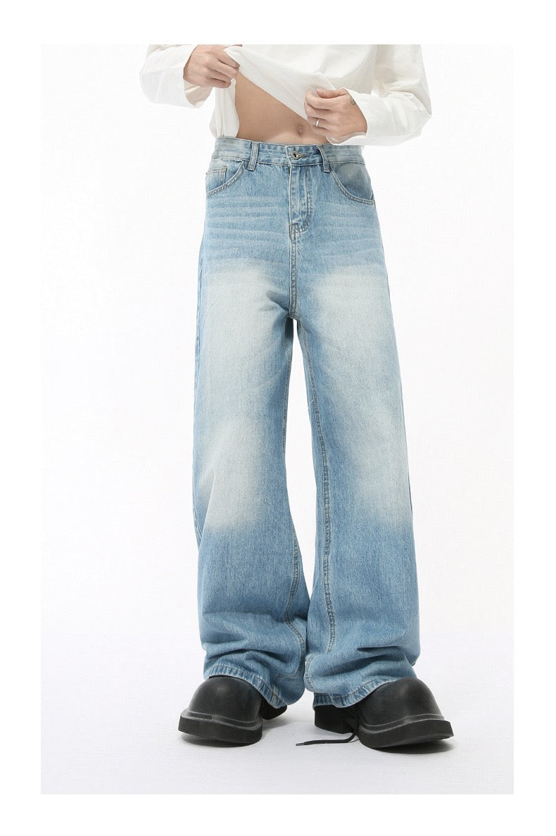 Light blue wide-leg jeans with faded wash worn by model, cropped front view