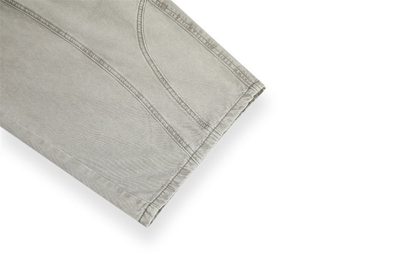 Close-up of light gray pants cuff with stitched seam detail