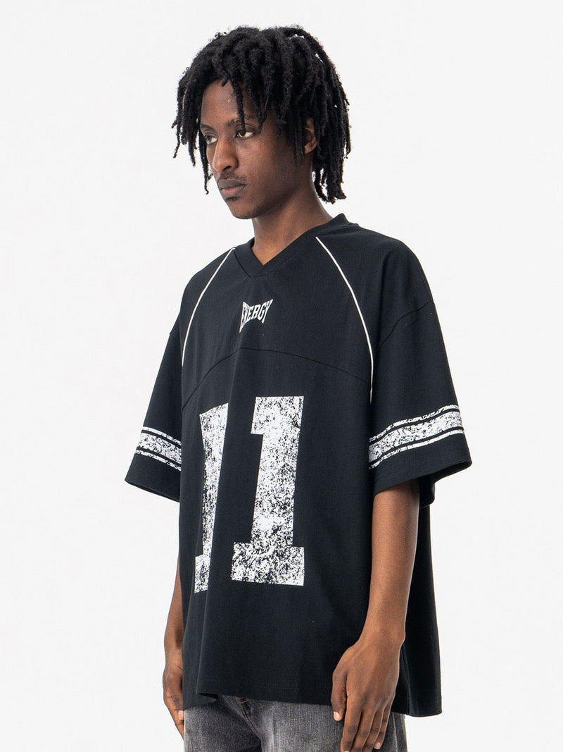Black oversized jersey T-shirt with vintage 11 graphic and white trim on a male model against a white background