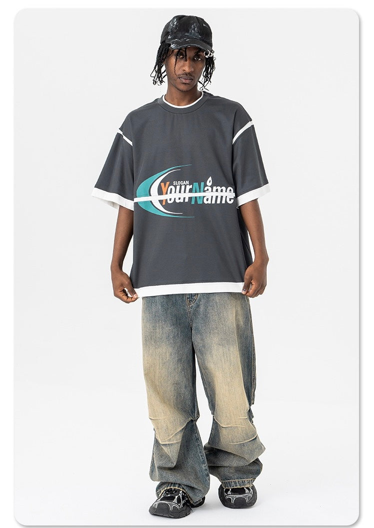 Oversized dark gray graphic mesh panel T-shirt with white trim, worn with baggy faded jeans and sneakers