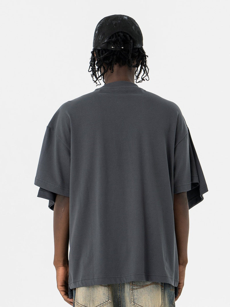 Oversized dark gray T-shirt with layered optical illusion sleeves, shown from the back on a model