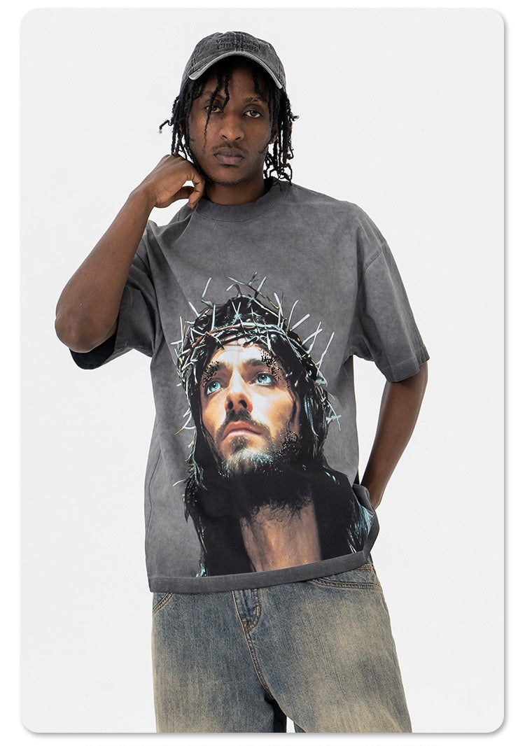 Washed gray oversized graphic tee with Crown of Thorns portrait print, worn with faded jeans and cap