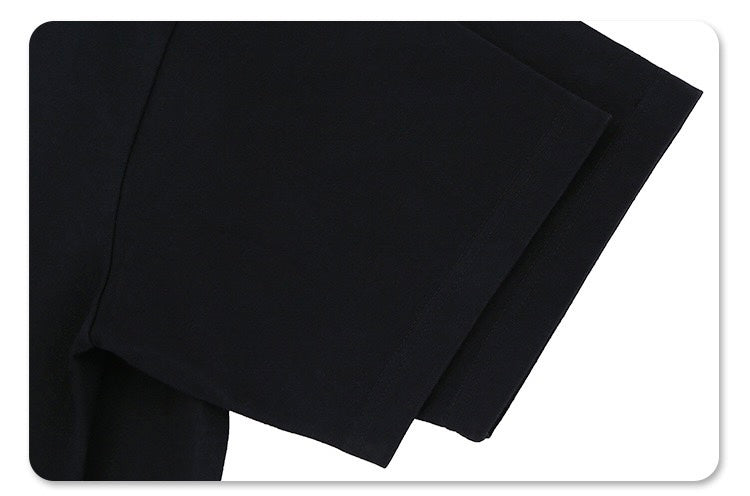 Black oversized graphic tee with relaxed fit and soft drape, shown folded against a white background