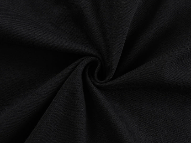 Black oversized graphic tee fabric with subtle ribbed texture and gathered folds, shown in a close-up view