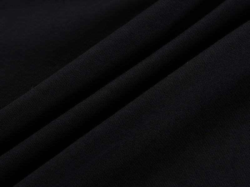 Black oversized graphic tee fabric close-up with subtle blue tones and soft folded texture