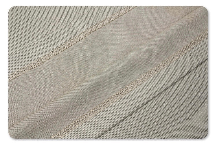 Close-up of beige knit fabric with raised panel seams and subtle retro texture on an oversized T-shirt
