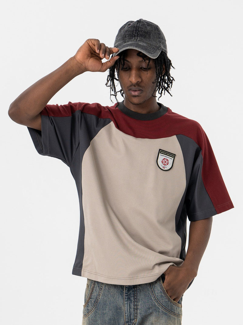 Oversized retro colorblock tee with cream, burgundy and charcoal panels, worn with jeans and a cap on a model