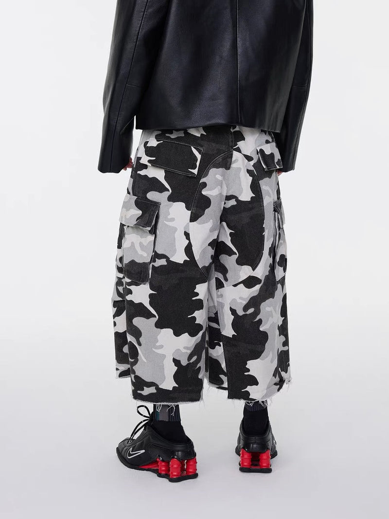 Back view of gray camo cargo shorts with frayed hems and black sneakers