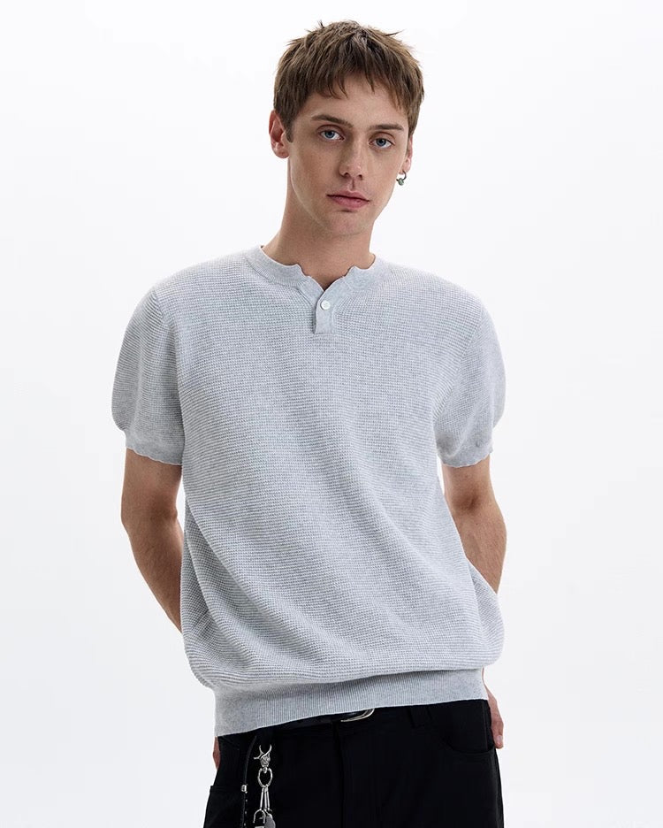 Light gray textured knit short sleeve polo tee on a model with a relaxed fit and henley-style neckline