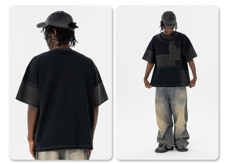 Black oversized patchwork panel T-shirt worn with baggy faded jeans and cap, streetwear style front and back view