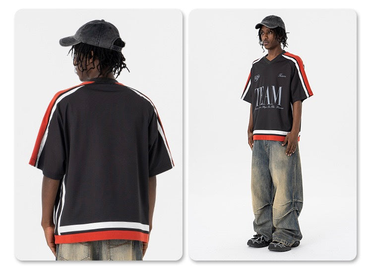 Black oversized mesh tee with red and white striped shoulders, TEAM graphic, worn with baggy jeans and cap