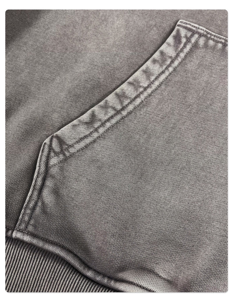 Close-up of hoodie kangaroo pocket seam and washed gray fabric texture