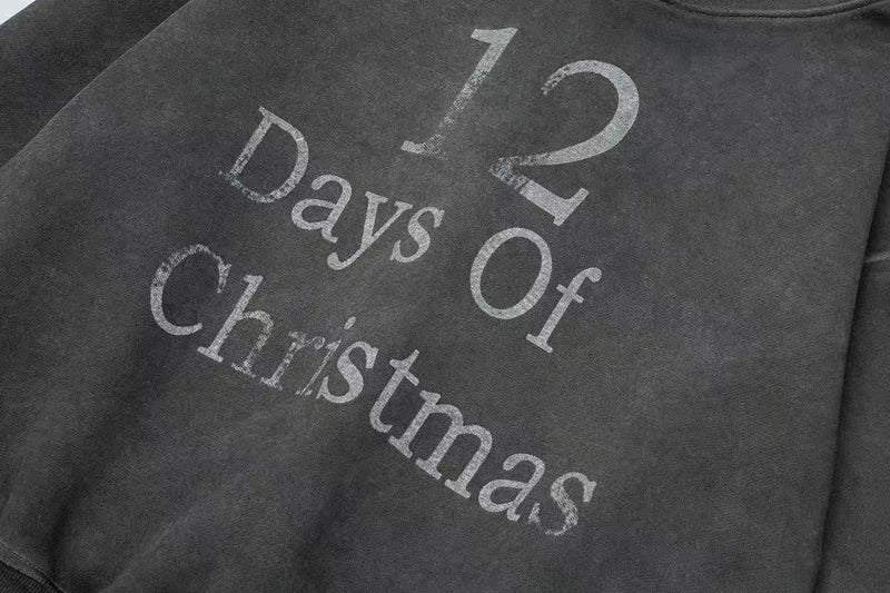 Close-up of black hoodie front with worn 12 Days Of Christmas text print