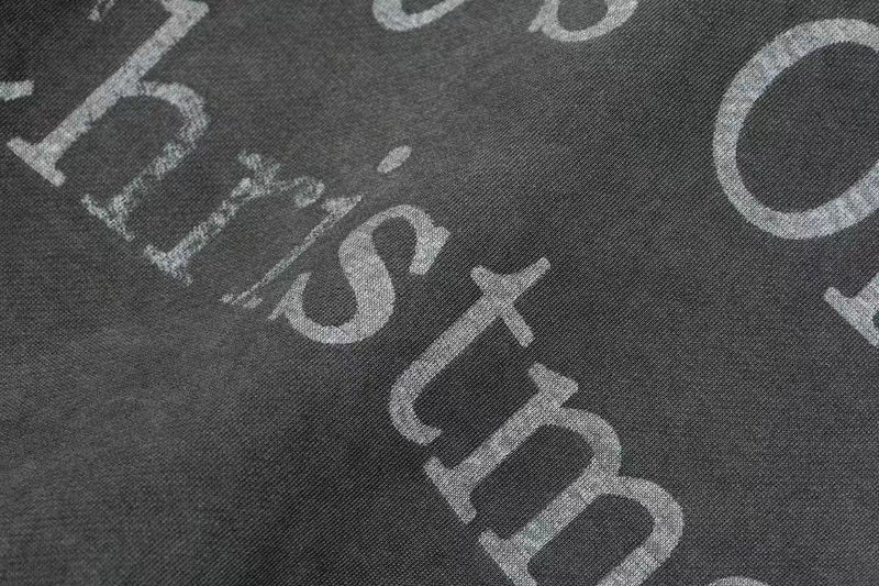 Close-up of faded Christmas lettering on black hoodie print