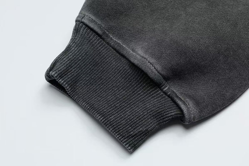 Close-up of black hoodie ribbed sleeve cuff and hem stitching