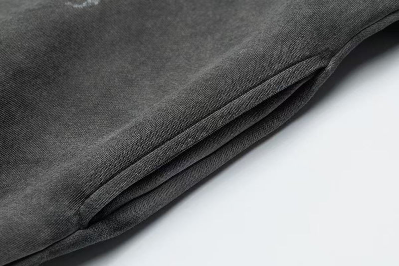 Close-up of black hoodie side seam and folded hem detail