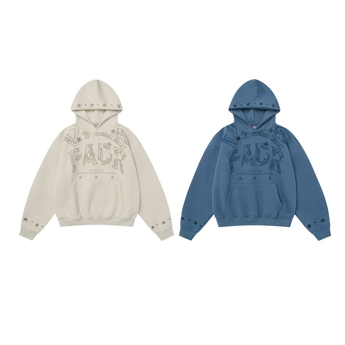 Cream oversized pullover hoodie with distressed letter graphic and metal star stud details on hood and sleeves
