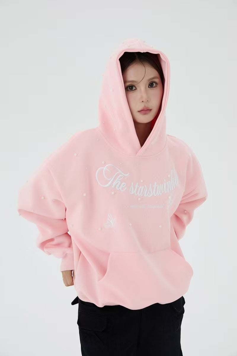 Pink pearl embellished hoodie worn by model with hood up, front view