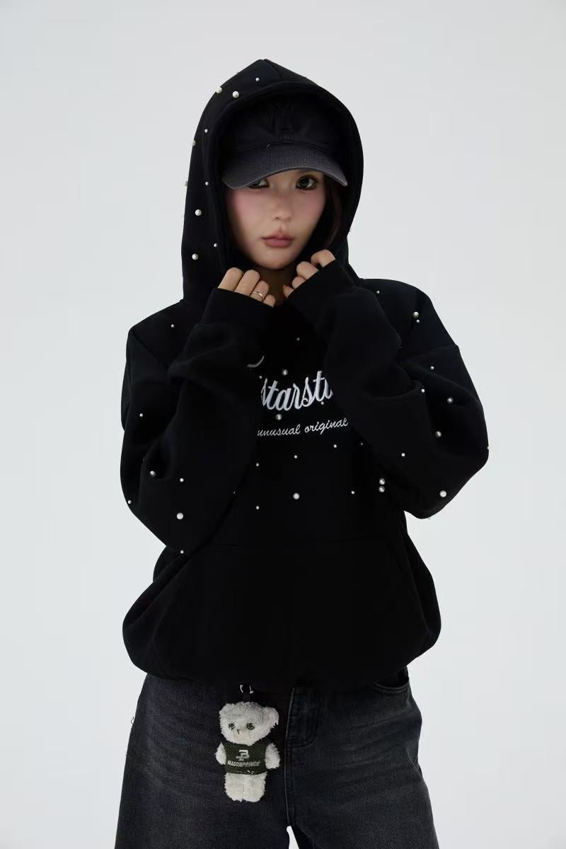 Black pearl embellished hoodie worn by model with hood up, front view