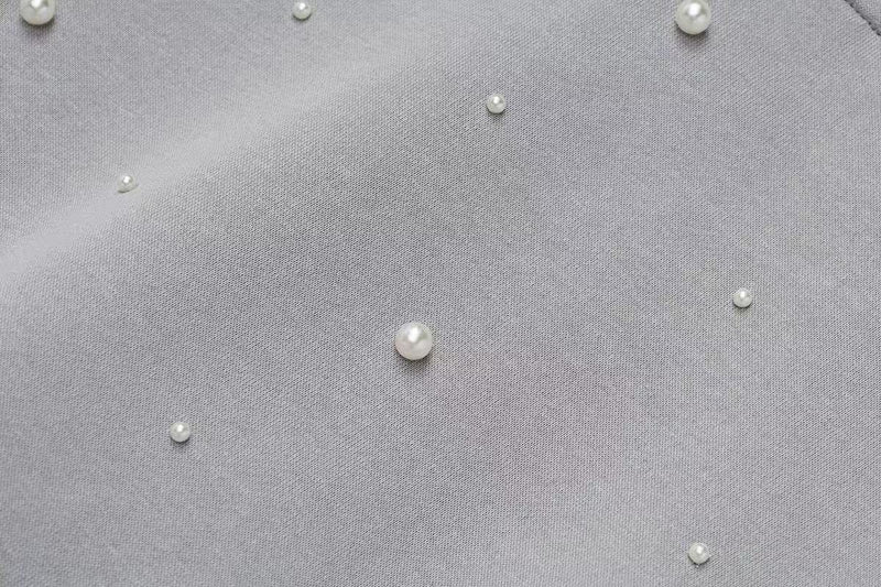 Close-up of gray hoodie fabric with scattered pearl embellishments