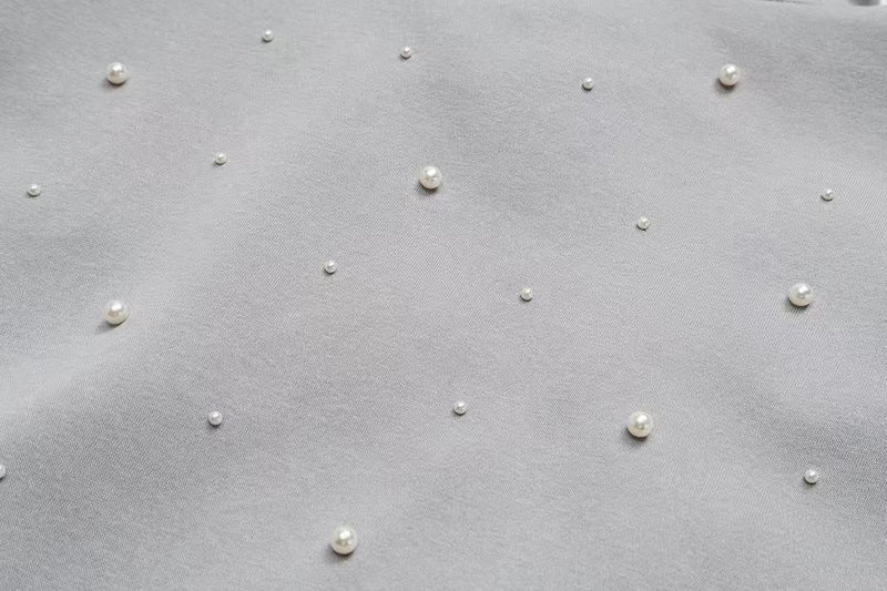 Close-up of gray hoodie back fabric with scattered pearl embellishments