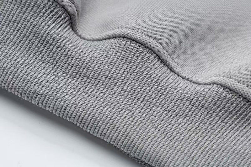 Close-up of gray hoodie ribbed hem and sleeve cuff stitching