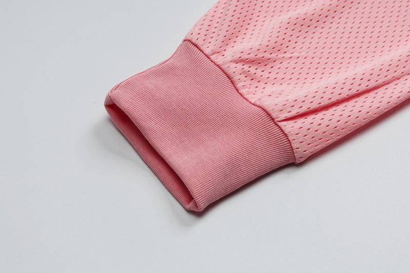 Close-up of pink ribbed cuff and perforated mesh sleeve fabric