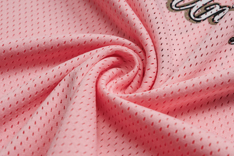 Close-up of pink mesh jersey fabric gathered into a spiral with perforated texture