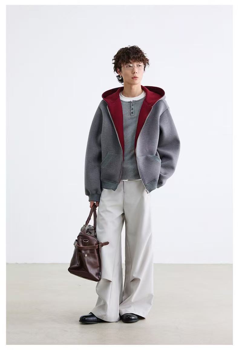 Model wearing gray zip-up hoodie with maroon hood lining and wide pants