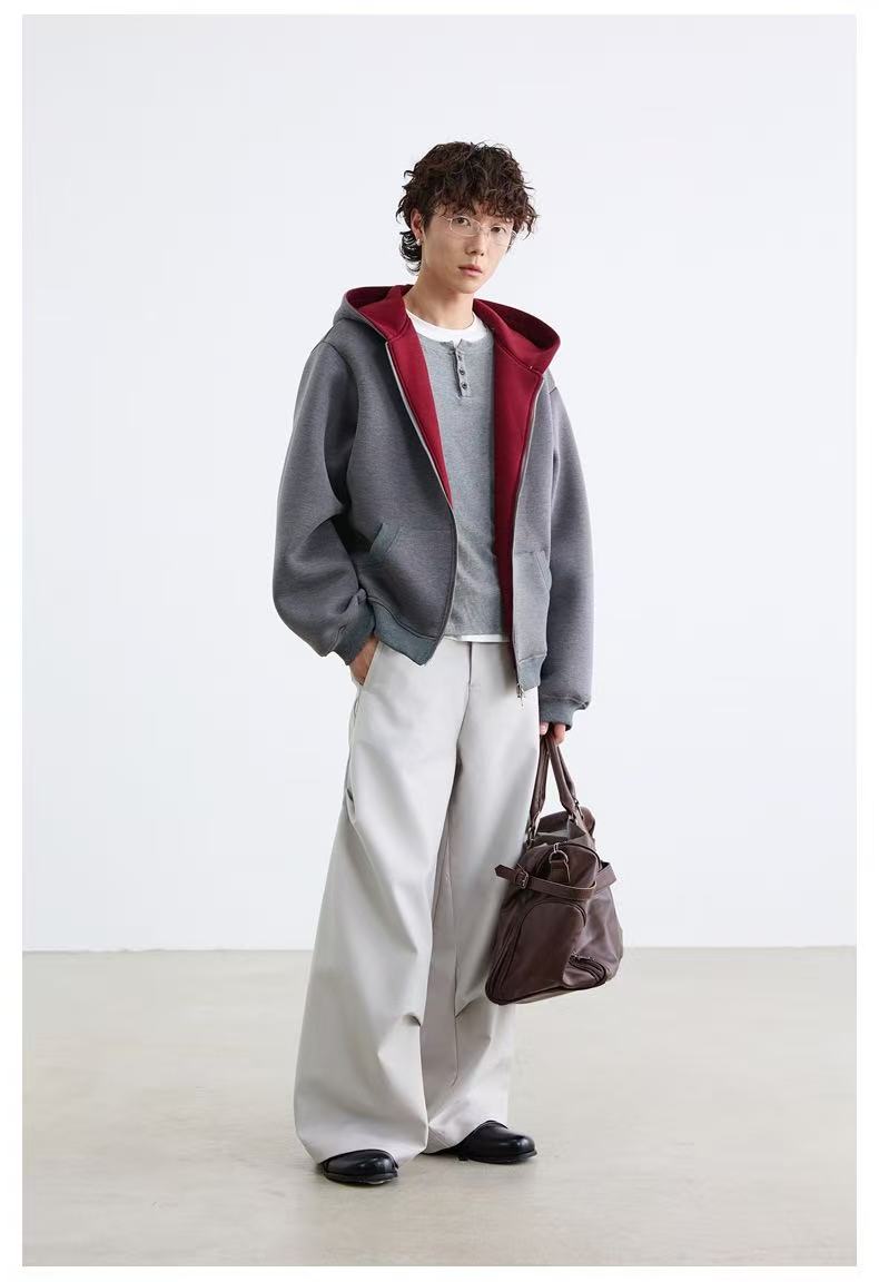 Side view of model in gray oversized zip-up hoodie with maroon hood lining