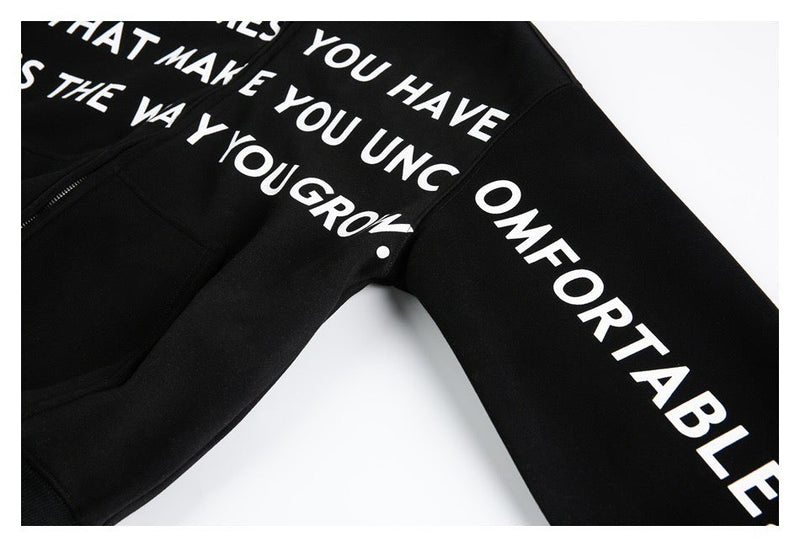 Close-up of black hoodie sleeve with white slogan print