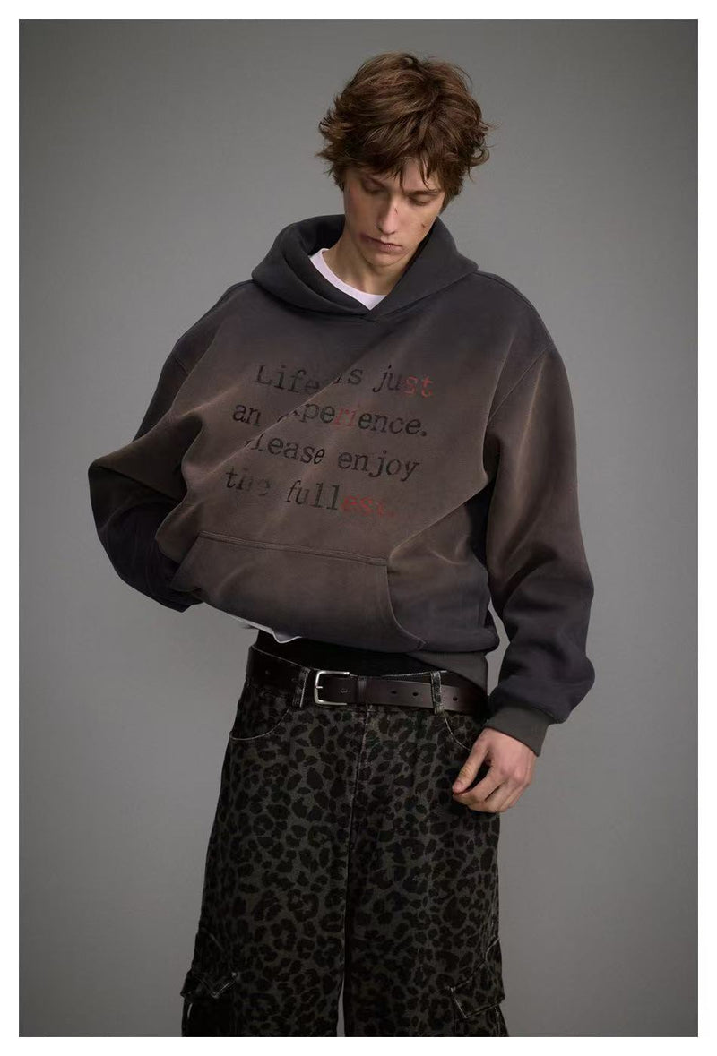 Close front view of dark washed hoodie showing the text print and hood