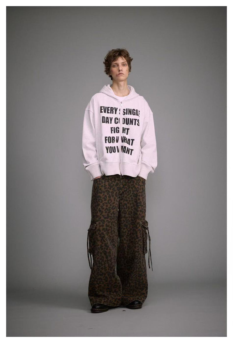 Model wearing white slogan zip-up hoodie with leopard-print cargo pants