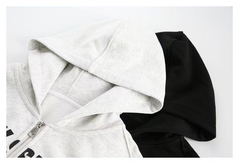 Close-up of white and black hoodie hoods, showing hood lining and zipper top