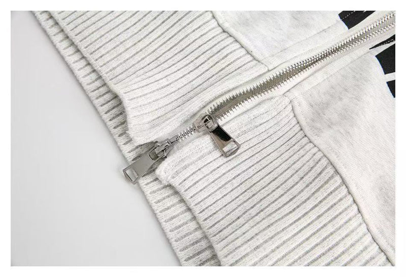 Close-up of white ribbed cuff and hem with zipper detail