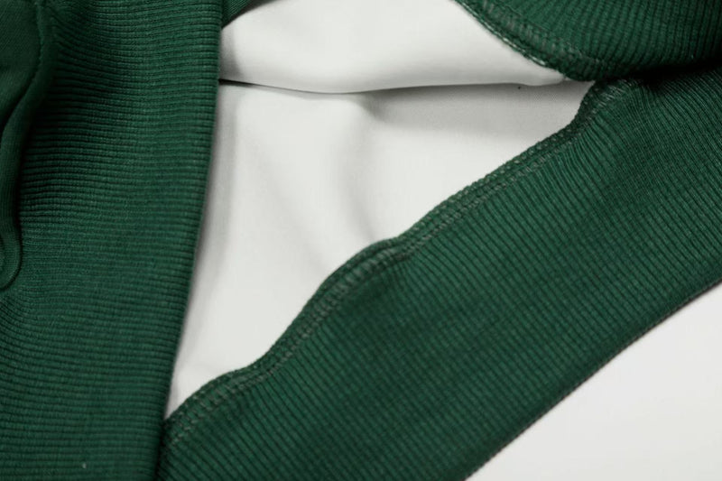 Close-up of dark green hoodie sleeve opening with ribbed cuff and inner lining