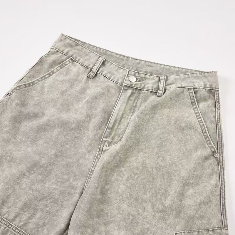 Close-up of light wash pants waistband, front pockets and button closure