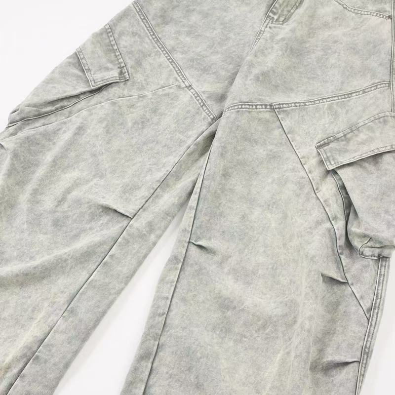 Close-up of light gray jeans leg with paneled seam and cargo pocket